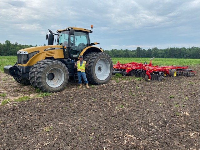 Challenger tractor and disc harrow working a field for soil preparation